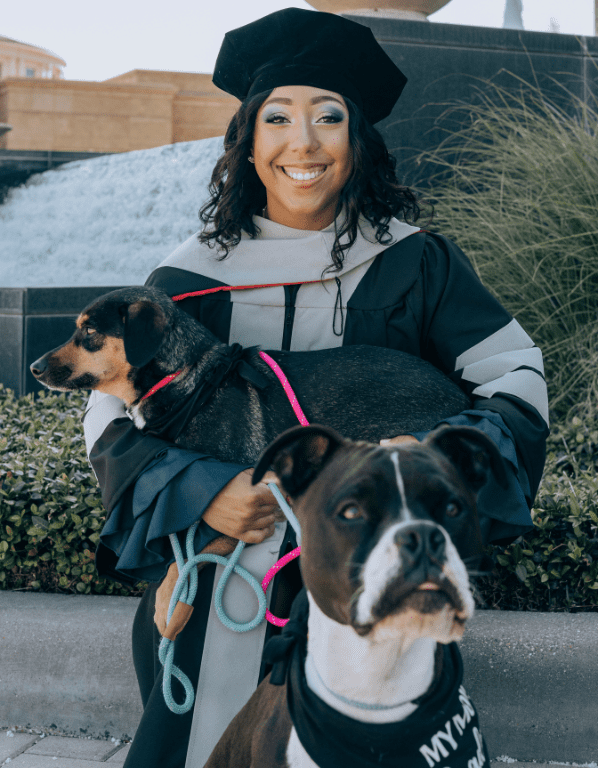 Dr. Nakia Sweetman, associate veterinarian, smiling with her dogs